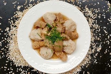 Goulash with oyster mushroom and buckwheat dumplings on the black background