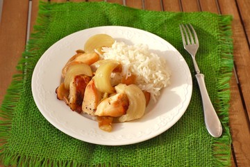 Rosted chicken with apples, onion and rice on the green gunny cloth