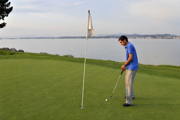 Obraz premium Young man playing golf