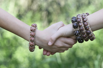 Teenagers handshake with boho styled jewelry. © gromush