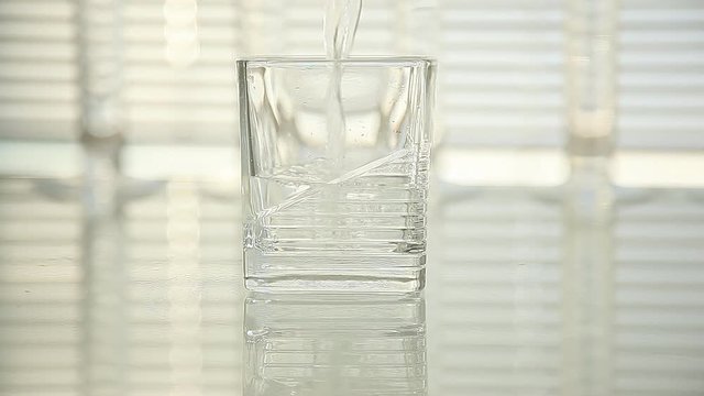 pure water is poured into a glass. close-up