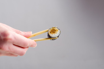 Jedzenie sushi pałeczkami - obrazy, fototapety, plakaty