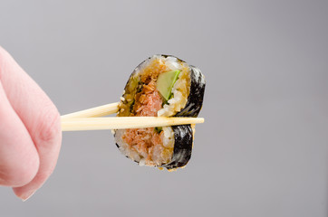 Jedzenie sushi pałeczkami - obrazy, fototapety, plakaty