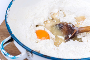 Raw egg in the flour with wooden scoop