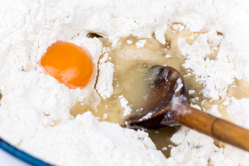 Raw egg in the flour with wooden scoop
