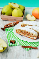 
dessert , apple strudel with cinnamon, sugar and spices on a wooden background   
