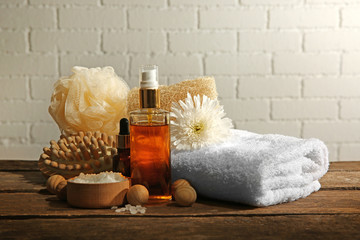 Variety of natural bath tools on wooden table, on bricks wall background