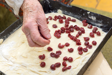 Grandmothers hand preparing cherry pie