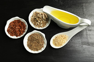 Different kinds of seeds and oil on wooden table