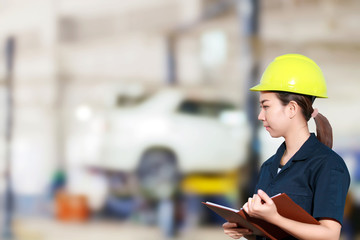 Portrait of smiling young female mechanic inspecting on a car in