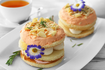 Tea with cakes on wooden background
