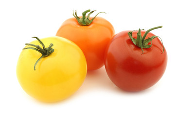 red, orange and yellow tomatoes on a white background