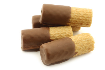 rolled up crispy chocolate wafers on a white background