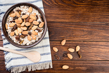 Healthy breakfast. Granola with nuts and raisins  in a wooden bowl  on a rustic background