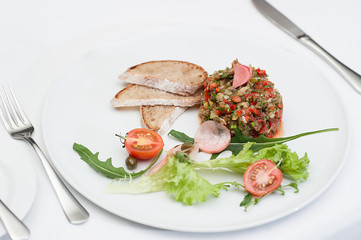 Aubergine Pate Served on a White Plate with Fork and Knife