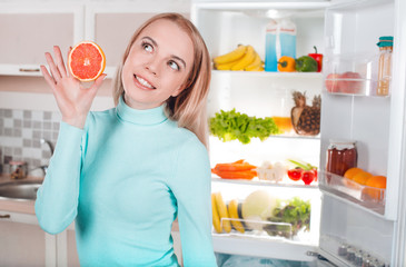 Young blonde at home near fridge