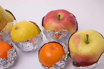 Juicy fruit, yellow pear, apple, lemon and orange tangerines wra