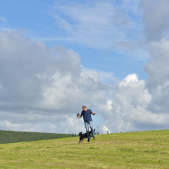 Summer landscape. Running young man and dog
