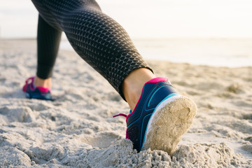 Close-up of female legs in tights and sneakers during morning ex