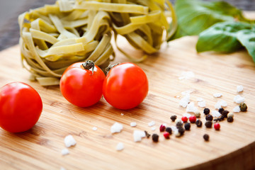 Fresh tomato and spaghetti (pasta) with Basil and a mixture of peppers on the Board