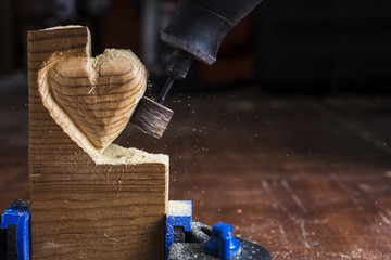 sanding wood in heart shape with a rotary tool