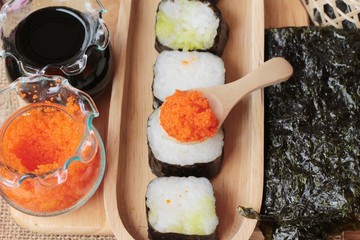 Making sushi roll with shrimp eggs delicious.