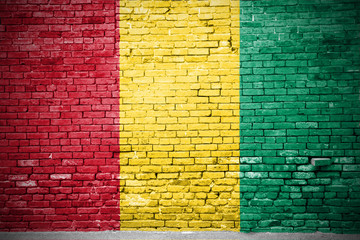 Ziegelsteinmauer mit Flagge Guinea