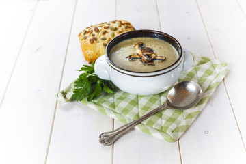 Mushroom soup with a bread roll and parsley