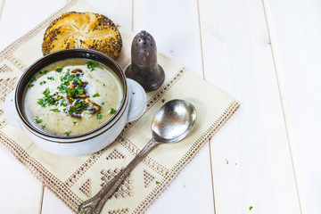 Mushroom soup with a bread roll and parsley