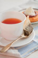 cup of tea with teaspoon and biscuit cakes