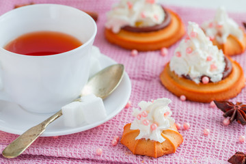 cup of tea with teaspoon and biscuit cakes