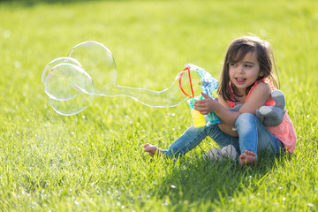 Little girl playing with soap bubbles machine