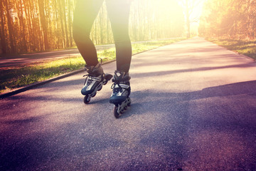 Teenage girl on roller skates at summer.