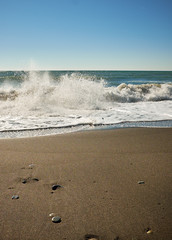 Waves wash over dark sand on the beach