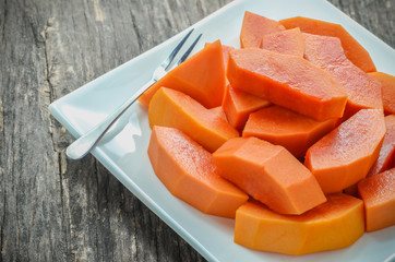 Slice of ripe papayas in white dish