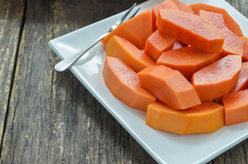 Slice of ripe papayas in white dish