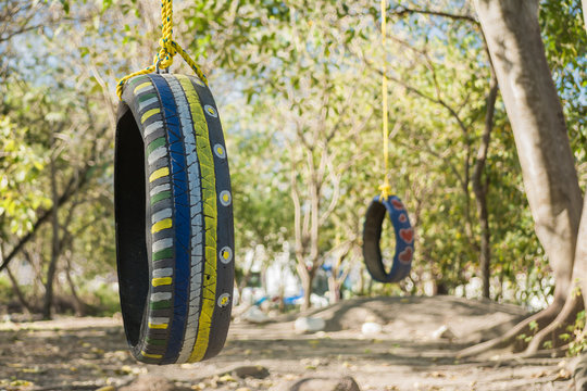 Dos llantas pintadas y adaptadas como columpios para que los ni&ntilde;os jueguen. 
