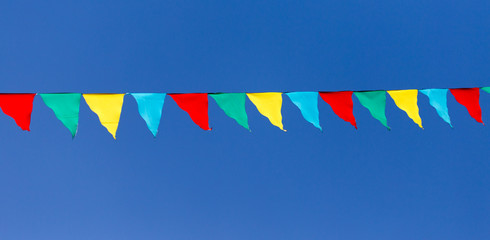 multicolored flags against the blue sky
