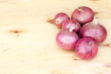 Bulbs of red onion on a wooden board