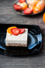 Raw vegan cheese cake with strawberries and oranges