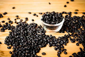 black bean seed on wooden rustic background in warm tone.