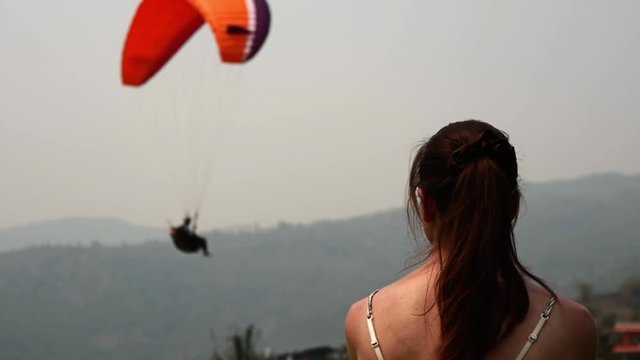 Woman and paraglider