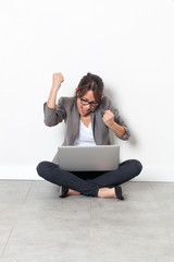 shouting young corporate woman or student raising hands for victory