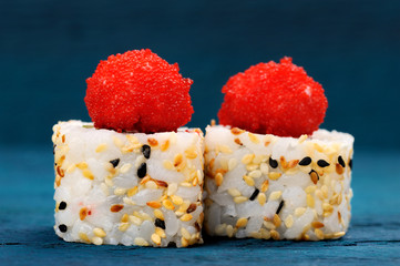 Yummy Japanese fusion rolls with sesame seeds topped with red roe