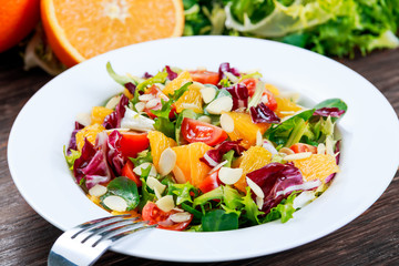Fresh Orange, strawberry vegetables salad. on wooden table.