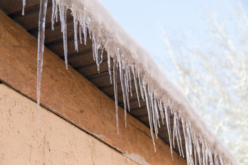 icicles on a roof of a house in winter
