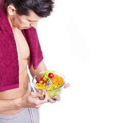 Fit young man holding a bowl of salad, isolated on white backgro