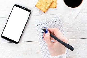 Woman sitting at table and pays the purchase through smartphone