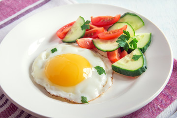 Fried egg with vegetable salad