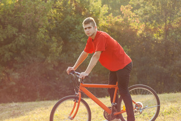 Fototapeta na wymiar Man ride orange bike at meadow